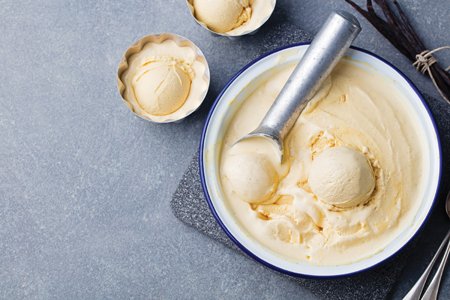 A bowl of ice cream is shown with a scoop sitting in it.