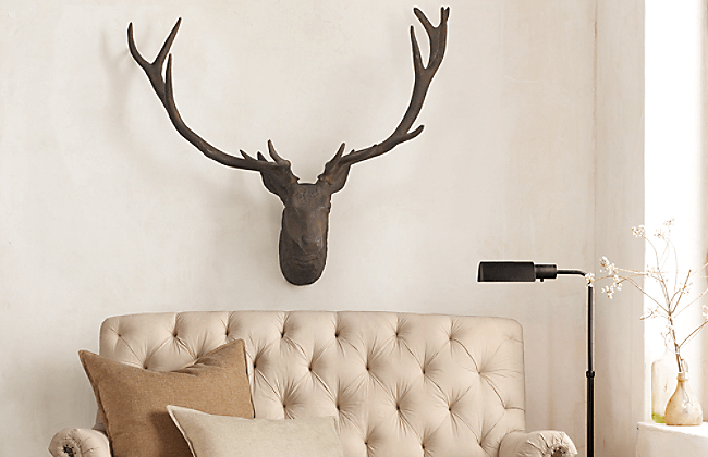 A set of antler horns is hung above a sofa.