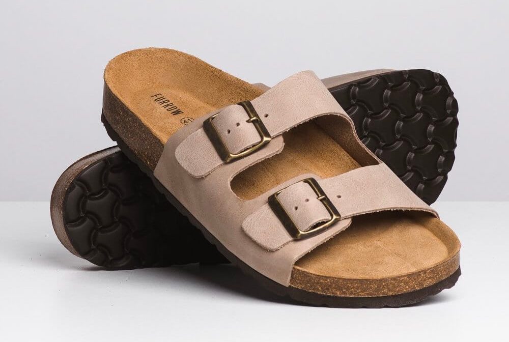 Two leather sandals are stacked on each other.