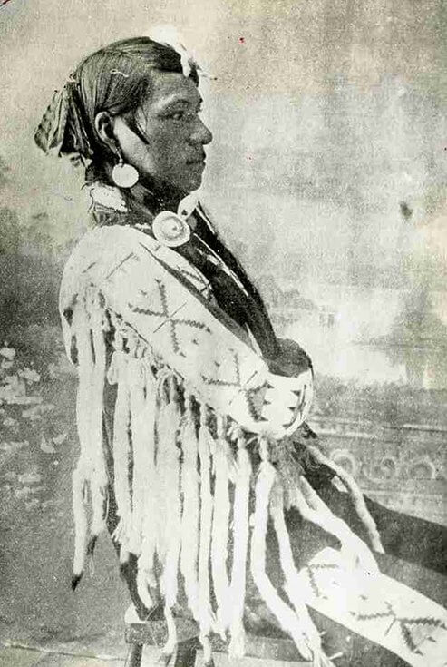 A young Cree brave in traditional dress ready for the Thirst Dance at Battleford NWT, 1882.