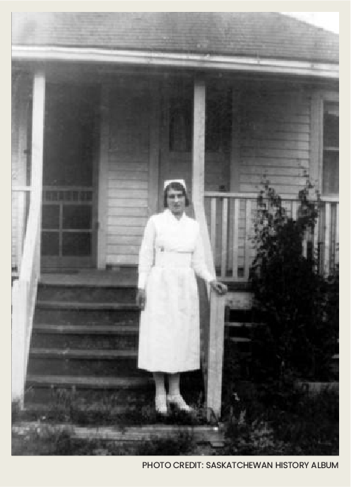 Photo caps-11 A young woman dressed as a nurse is standing on the front steps of a wooden house.