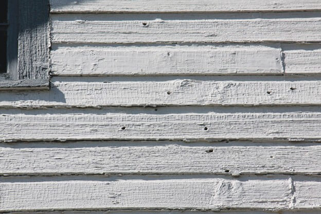 A piece of art by Leah Marie Dorion made with mosaics shows two Indigenous people standing near animals, sun, and water. 