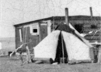 A piece of art by Leah Marie Dorion made with mosaics shows two Indigenous people standing near animals, sun, and water. 